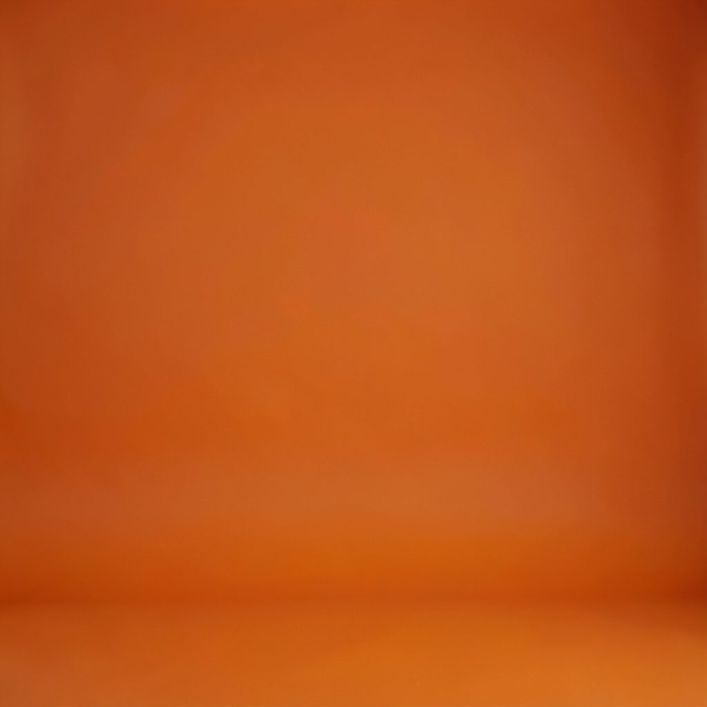 Studio photograph of a brass desktop globe on a seamless warm ivory backdrop, muted golden tones, classic newsroom mood